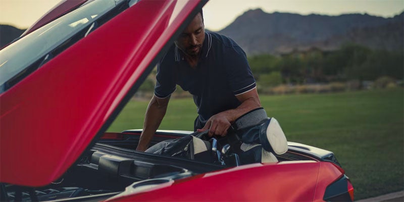 A man repairs his car using a wrench
