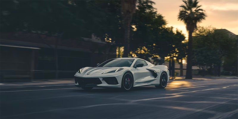 A 2025 Chevrolet Corvette driving along a bustling city street.
